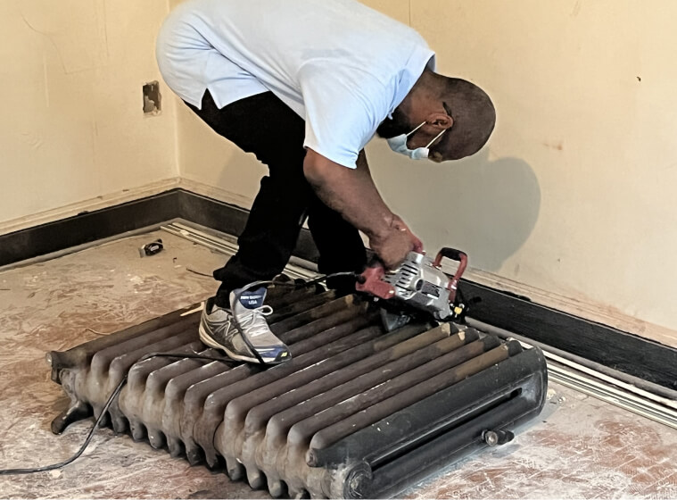 man removing old radiator from home