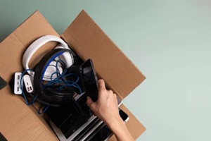 woman hand collect old used computers, digital tablets, smartphones, electronic devices to cardboard box