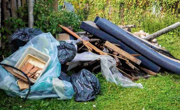 garbage and a pile of construction debris in the yard of a house in Baltimore City