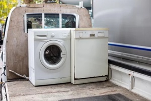 old discarted dishwasher and washing machine on a vehicle truck for recycling